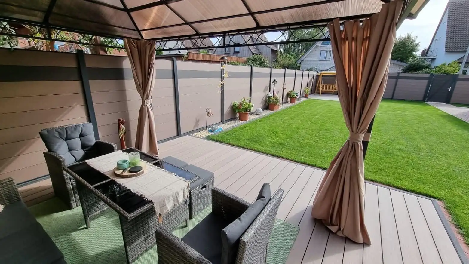 WPC-Sichtschutzzaun mit Terrassendielen und Rasen
